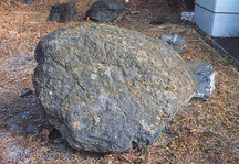 地表に置かれた表面がごつごつした大きな灰色と茶色の岩の写真