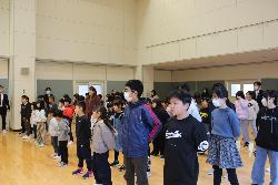 2学期の終業式に参加するため、多目的教室に全校で集まり、整然と整列した児童の様子