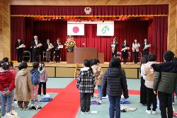 全校で校歌を歌い、離任する方々を見送る全校児童の様子