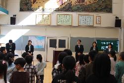披露式で転入職員を迎える児童と転入職員の様子
