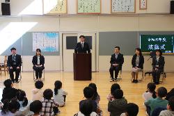 披露式で転入教職員を紹介する校長の様子