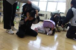 通学路上で災害が発生した場合の身を守る方法について練習する児童の様子