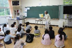 読み聞かせボランティアの絵本の読み聞かせに耳・目を傾ける児童の様子1