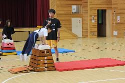 跳び箱の跳び方のコツを教える亀山選手の様子
