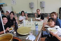 できあがったカレーを食べる児童とお母さんの様子