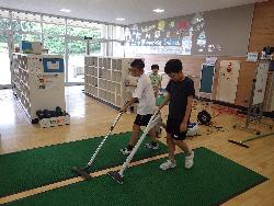 昇降口のマットに掃除機を掛ける児童の様子