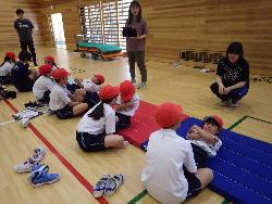 上体起こしに挑戦する児童とそれを見守る南三陸高校の生徒の様子