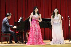 シュガーシスターズが声を揃えて歌声を披露している様子