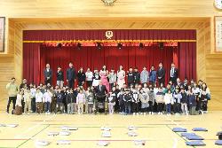 シュガーシスターズと全校児童で記念写真撮影の様子