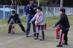 水消化器で消火訓練を行う子供たちの様子