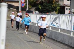 歩道のコースを一生懸命走る1年生の様子