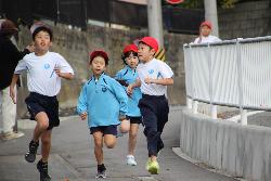 友達と競い合って走る子供の様子