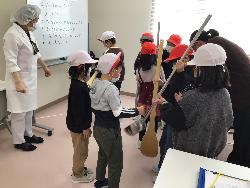 調理をする際の道具の大きさに驚きながら道具をもたせてもらっている子供たちの様子