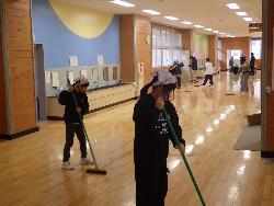 全校児童で校舎1階の廊下を掃除している様子