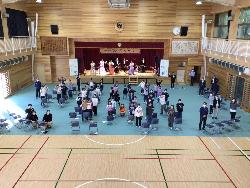 会の終わりにステージ上の演奏者とフロアーの子供たちで記念写真撮影をする様子