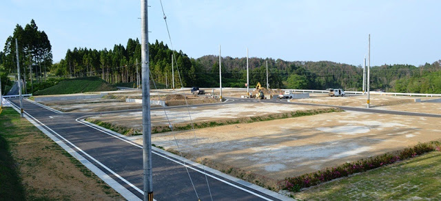 複数の住宅区画が整地され、舗装された道路が敷かれた広い造成地の写真