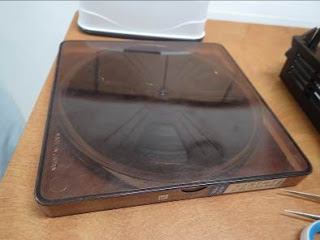 茶色い透明のケースに入った黒い円形のフィルムの写真