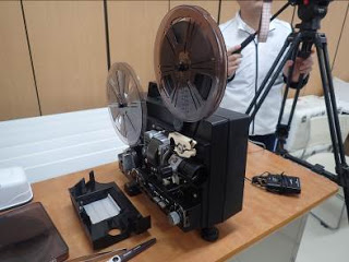 黒い映写機にフィルムがセットされている写真