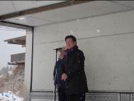 マイクの前に立ち、話をしている男性の写真