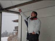 マイクの前に立ち、右手を高く上げて声を出している様子の写真