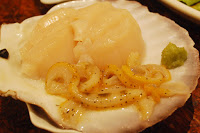 ホタテの貝殻に盛られた貝の刺身の写真