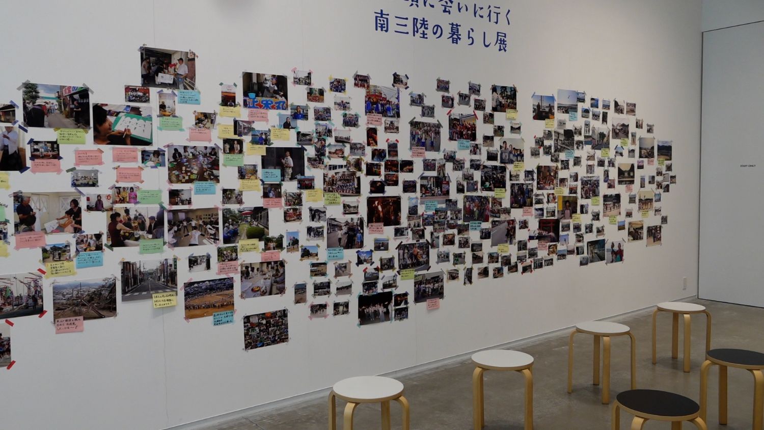 カラフルな紙に書かれたメッセージとともに、壁一面に並べられた写真群が震災前後の南三陸の生活や祭り、地域の人々の姿を記録している展示風景の写真