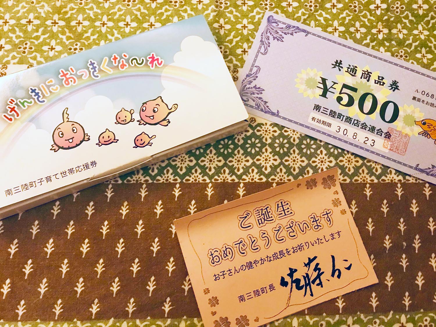 ご誕生おめでとうございますのメッセージカードと子育て世帯応援券の写真