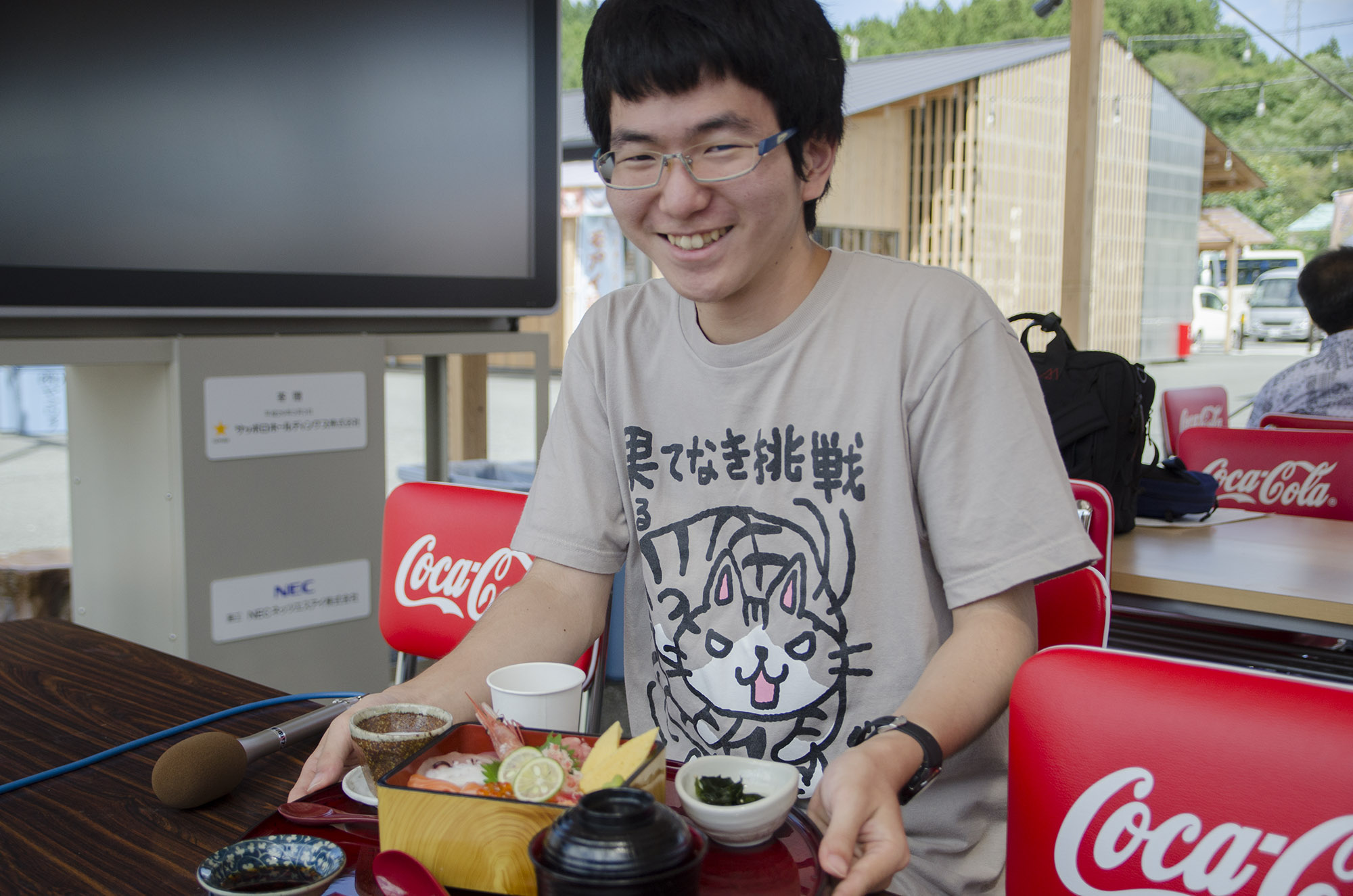笑顔で海鮮丼のセットが乗ったおぼんを前にしている平野さんの写真