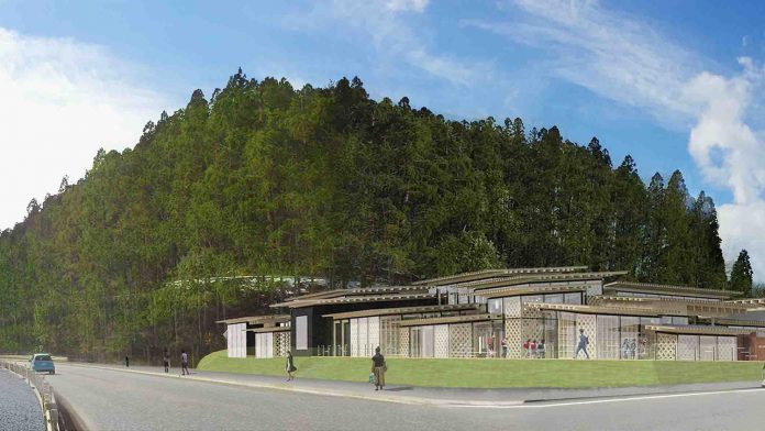 後方に緑豊かな木々があり、近代的な建物の生涯学習センターが道路に面しており、建物は低層でガラス壁が多く、芝生が建物周囲に広がっている様子で、数人の人々が歩いているイメージ図写真