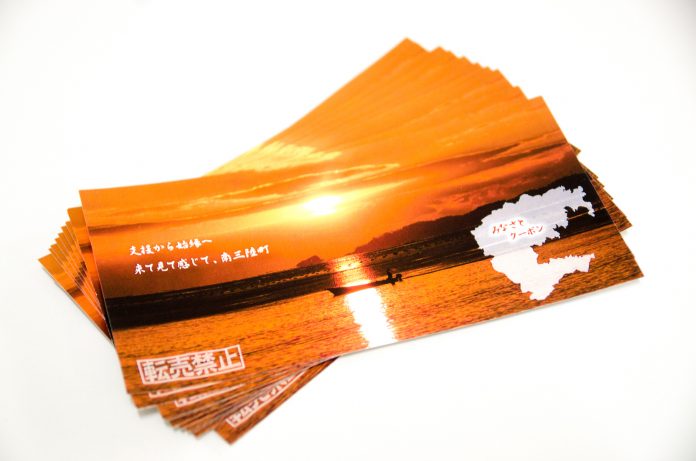 夕日の海に漁船が浮かぶオレンジ色の写真を背景に、南三陸町のシルエットと「みなさとクーポン」の文字が書かれたクーポンが何枚も重なって置かれている写真