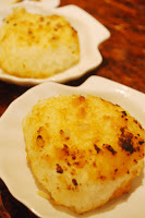 ホタテの形の皿に焼きおにぎりが一つづつ盛り付けられた写真