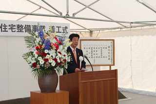 壇上には大きな花瓶に色とりどりの花が飾られ、壇上に佐藤町長が立ち式辞をしている様子の写真