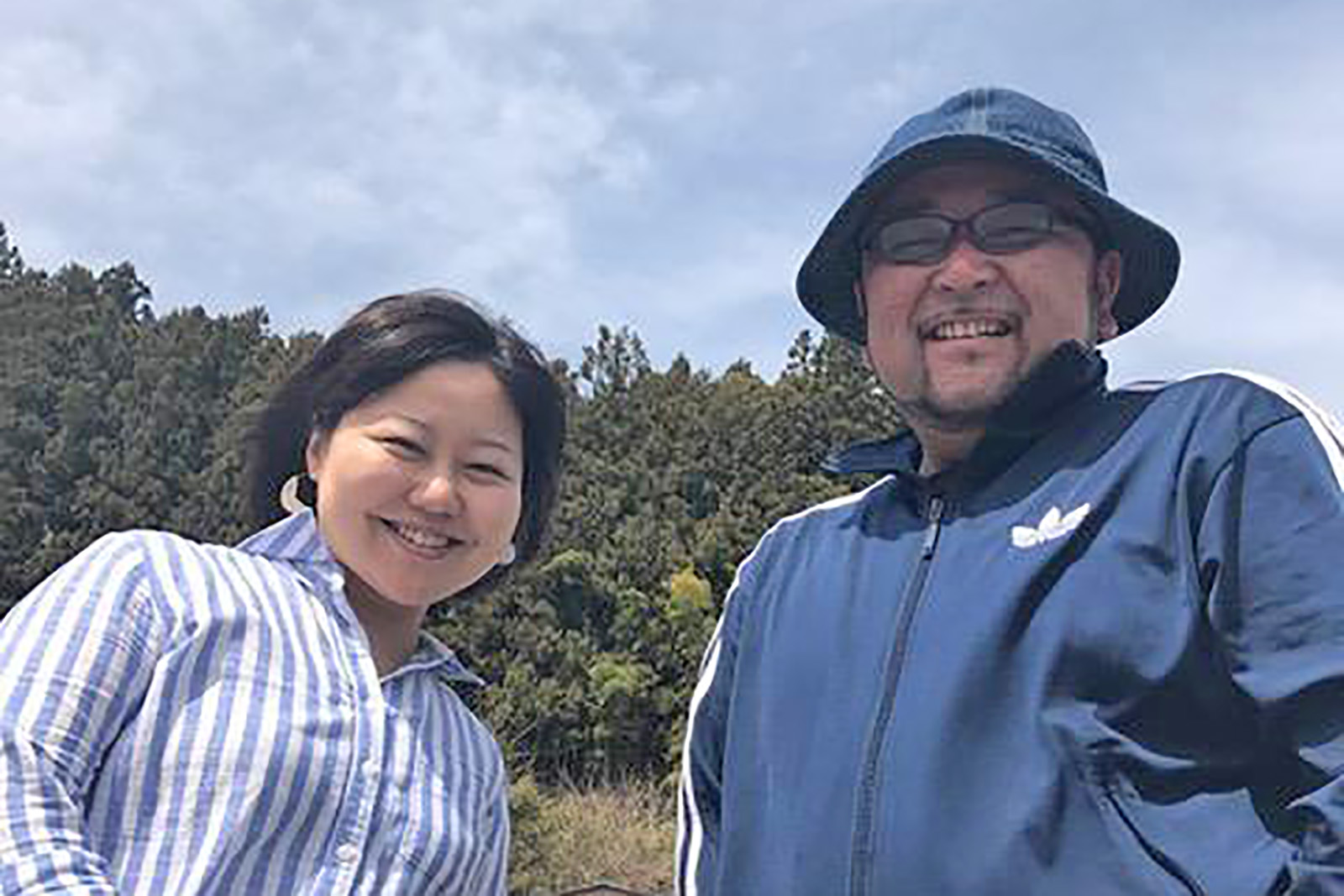 緑豊かな森を背景に、笑顔で並んだ女性リポーターと小野寺さんの写真