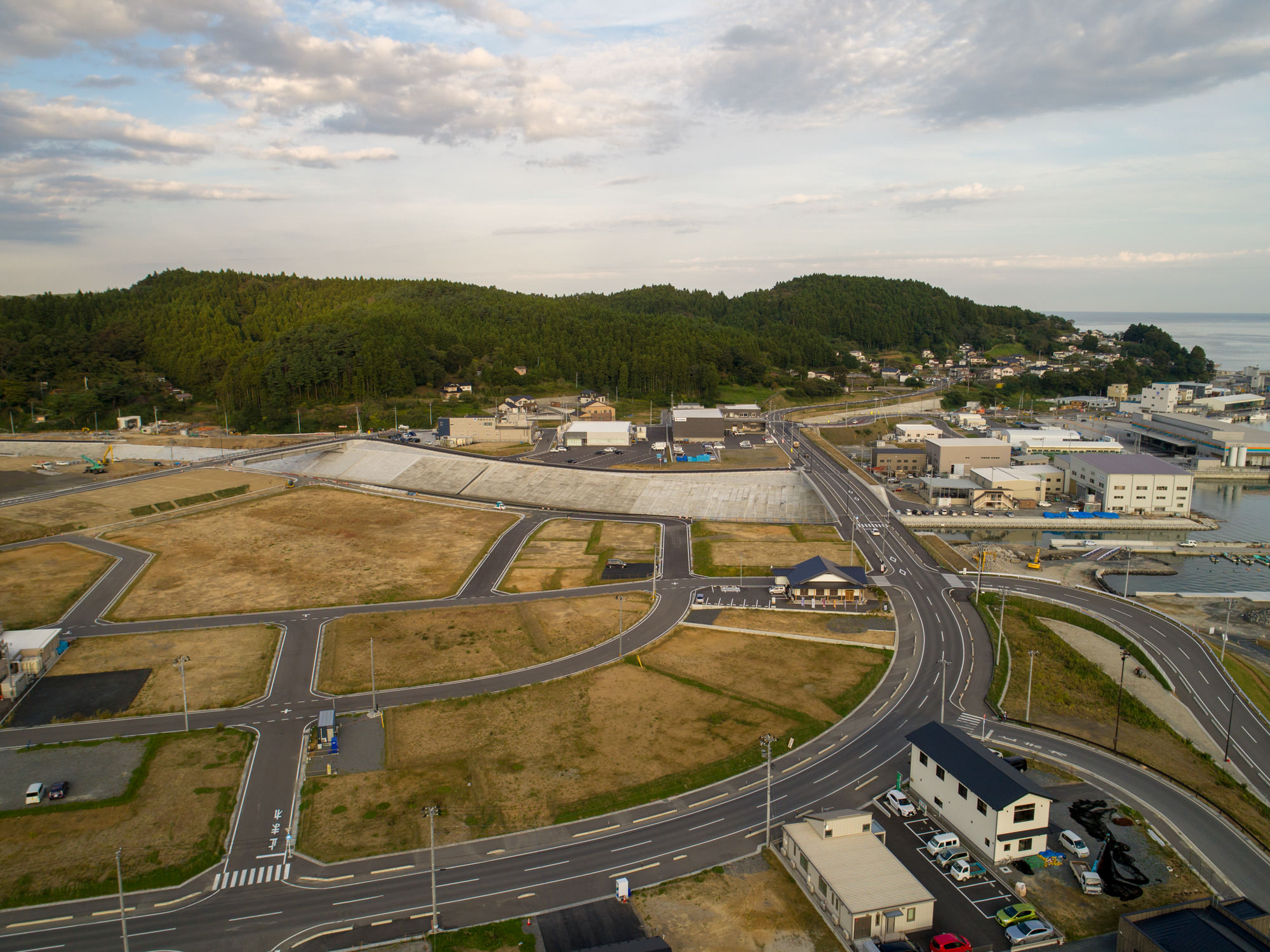 右側に建物が並び、カーブの道路がのび整地されている様子を写した写真