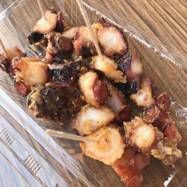 透明のプラスチック容器に入った、ぶつ切りのタコをから揚げにした「たこから」の写真