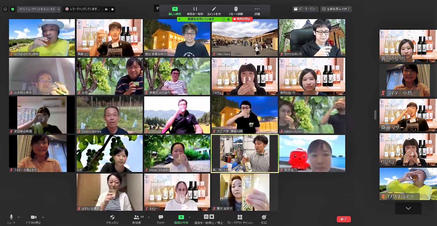 オンラインツアーの画面に多数の参加者が映り、それぞれが飲み物を持って乾杯している様子が表示されている写真