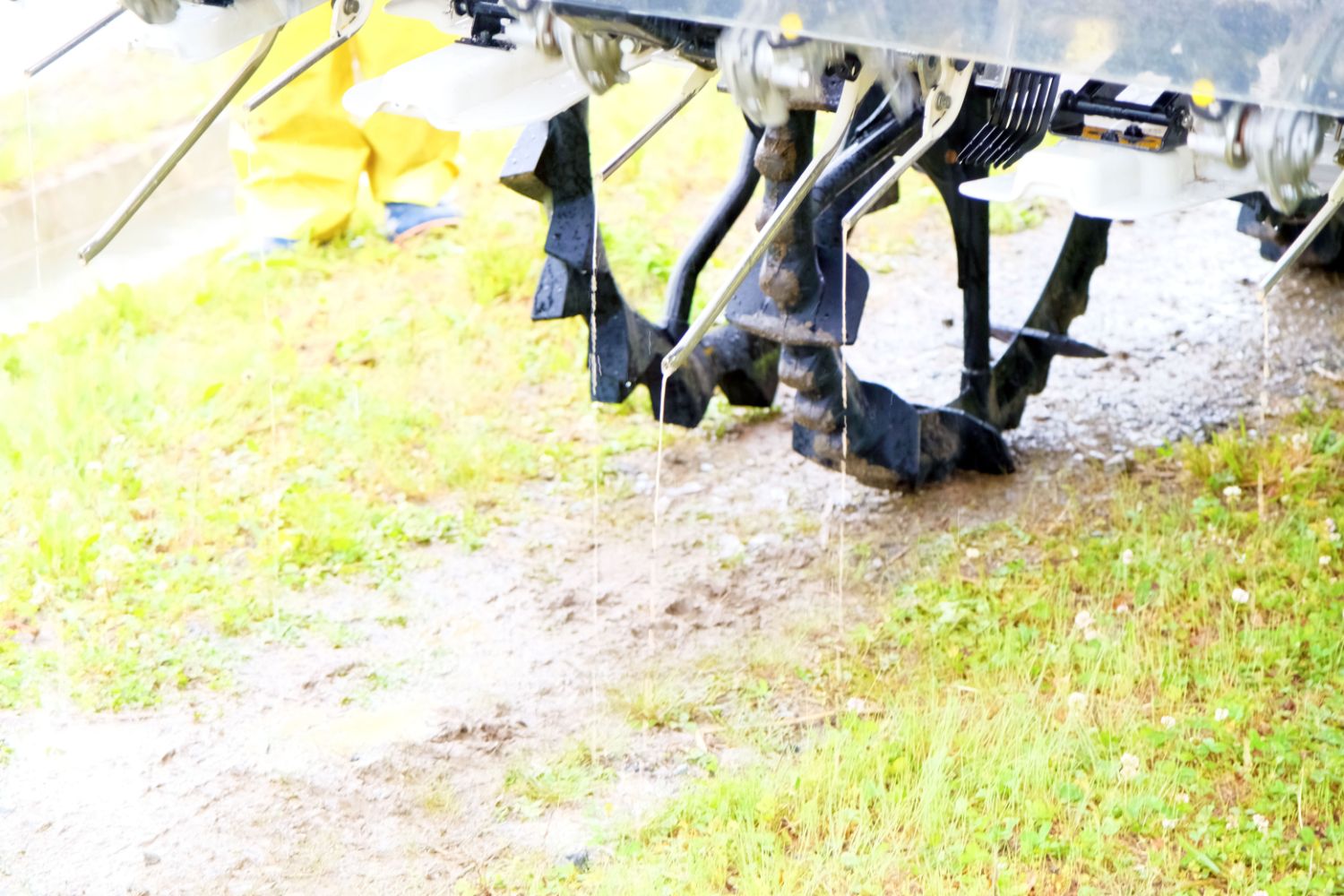 田植え機の後方についた複数のノズルからペースト肥料が出ている様子の写真