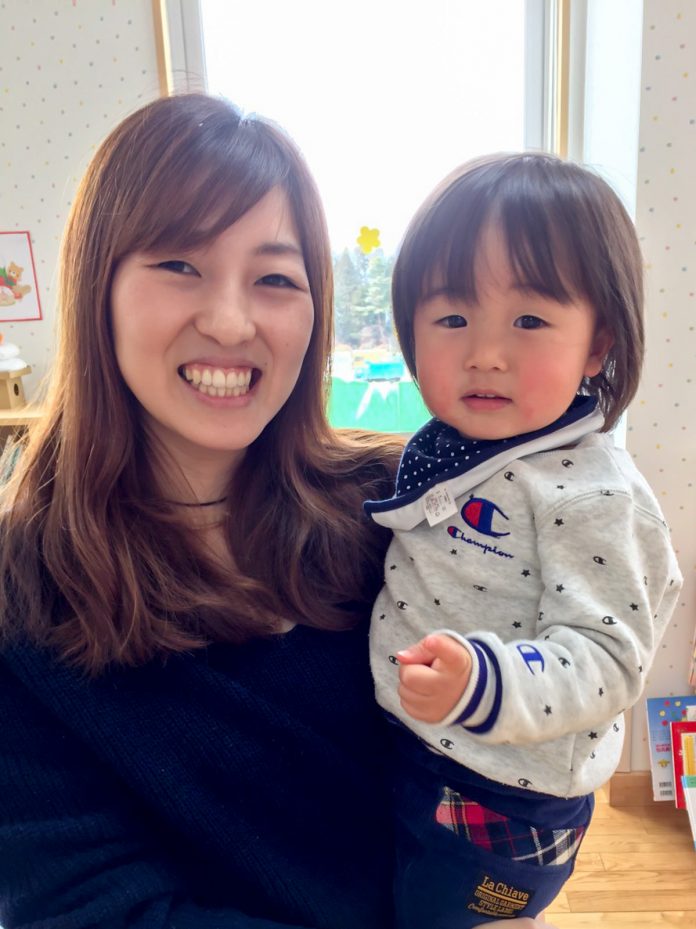 小さな男の子を抱っこした菅原千秋さんが男の子と一緒にカメラに笑顔を向けている写真