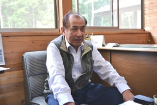 椅子に座っている山内日出夫さんの写真