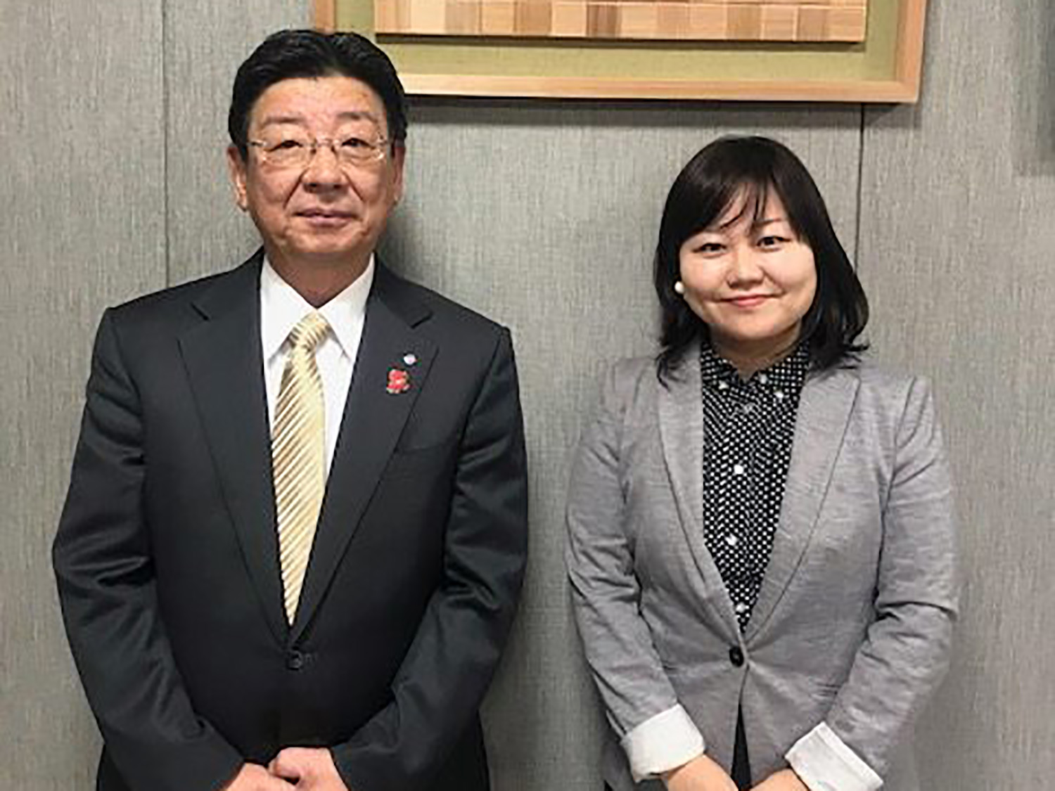 佐藤町長とリポーターの女性が笑顔で並んで立っている写真