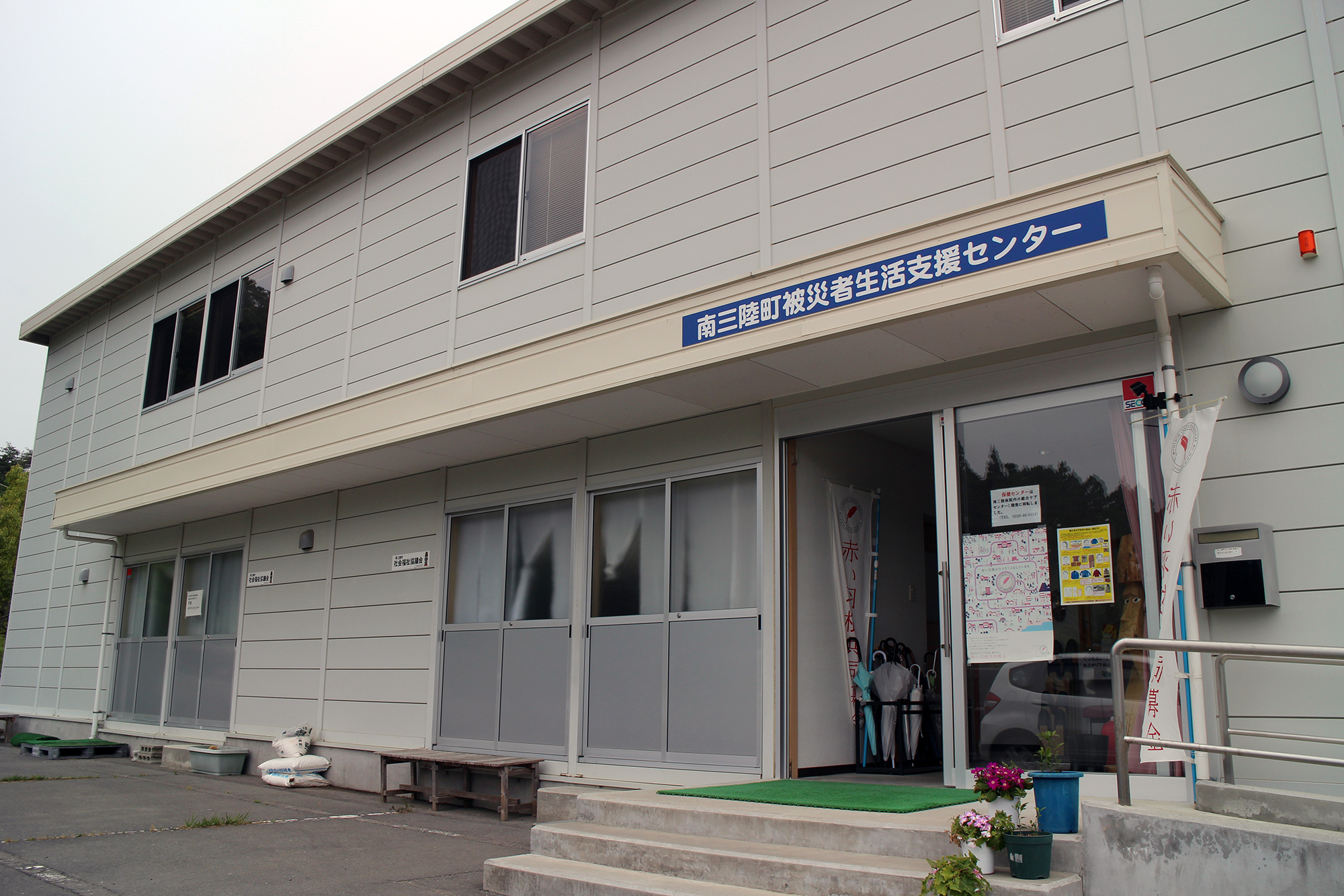 南三陸町被災者生活支援センターの入口がある二階建ての建物外観の写真