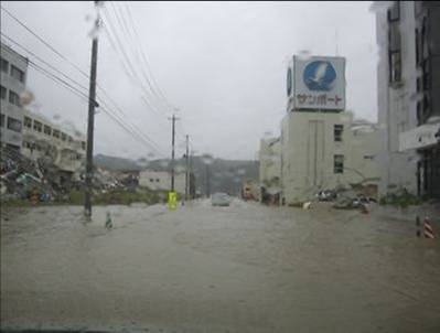 道路全体が冠水し、両側の建物まで水が達している、雨による冠水時の市街地の様子を写した写真