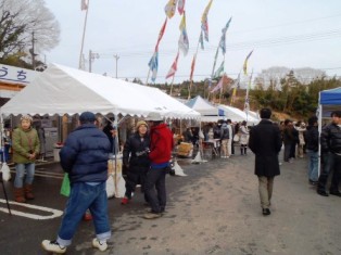 様々な商品が出店されたテントが並び、多くの人々が買い物を楽しんでいる様子を捉えた写真