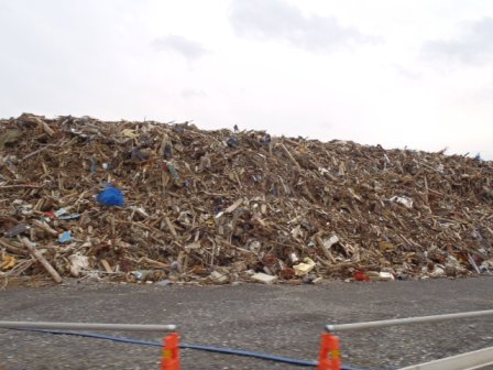 高さ数メートルにも積み上げられた様々な素材が混在した大量のがれきの山の写真