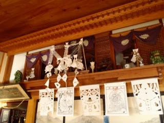 神棚の上に切子の飾りが吊るされ、和紙に描かれた繊細な模様が並ぶ室内の写真