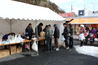 白いテントの下で福引のお楽しみ抽選会が行われており、テント前に人の列できている様子を写した写真