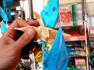 「福光」「一緒にうたおう」のメッセージが一つずつ書き込まれている連なった折り鶴を見せている写真