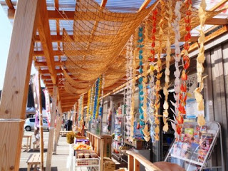 伊里前福幸商店街の軒先に折り鶴が連なったものがたくさん下げられている様子を写した写真