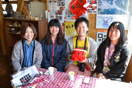 オクトパス君のぬいぐるみを持った代表の湯澤真さんと3名の関係者の女性が横に並んで笑顔で写っている写真