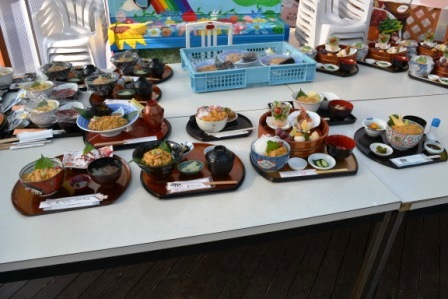 白いテーブルの上に複数の和風料理のセットが並んでいる写真